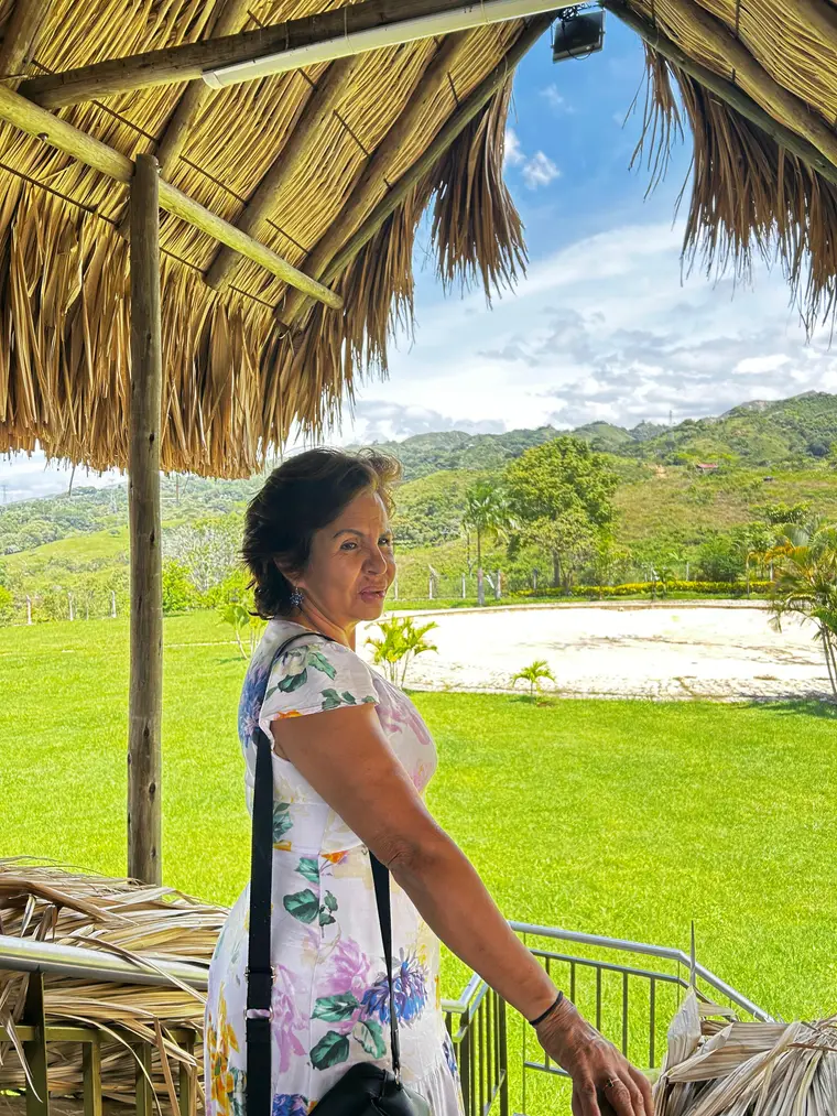 La madre fundadora bajo el kiosco, con el jardín y las lomas de Calambeo detrás