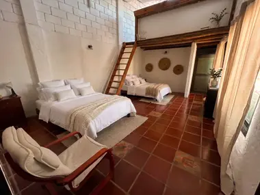Habitación María Concepción Loperena: dos camas dobles y televisor