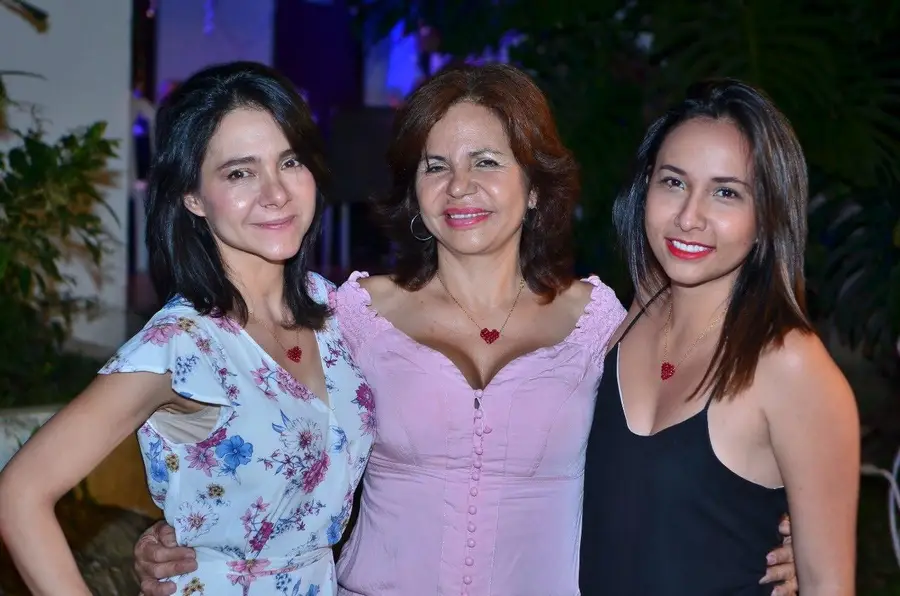 Tres mujeres posando juntas, del brazo, en la casa